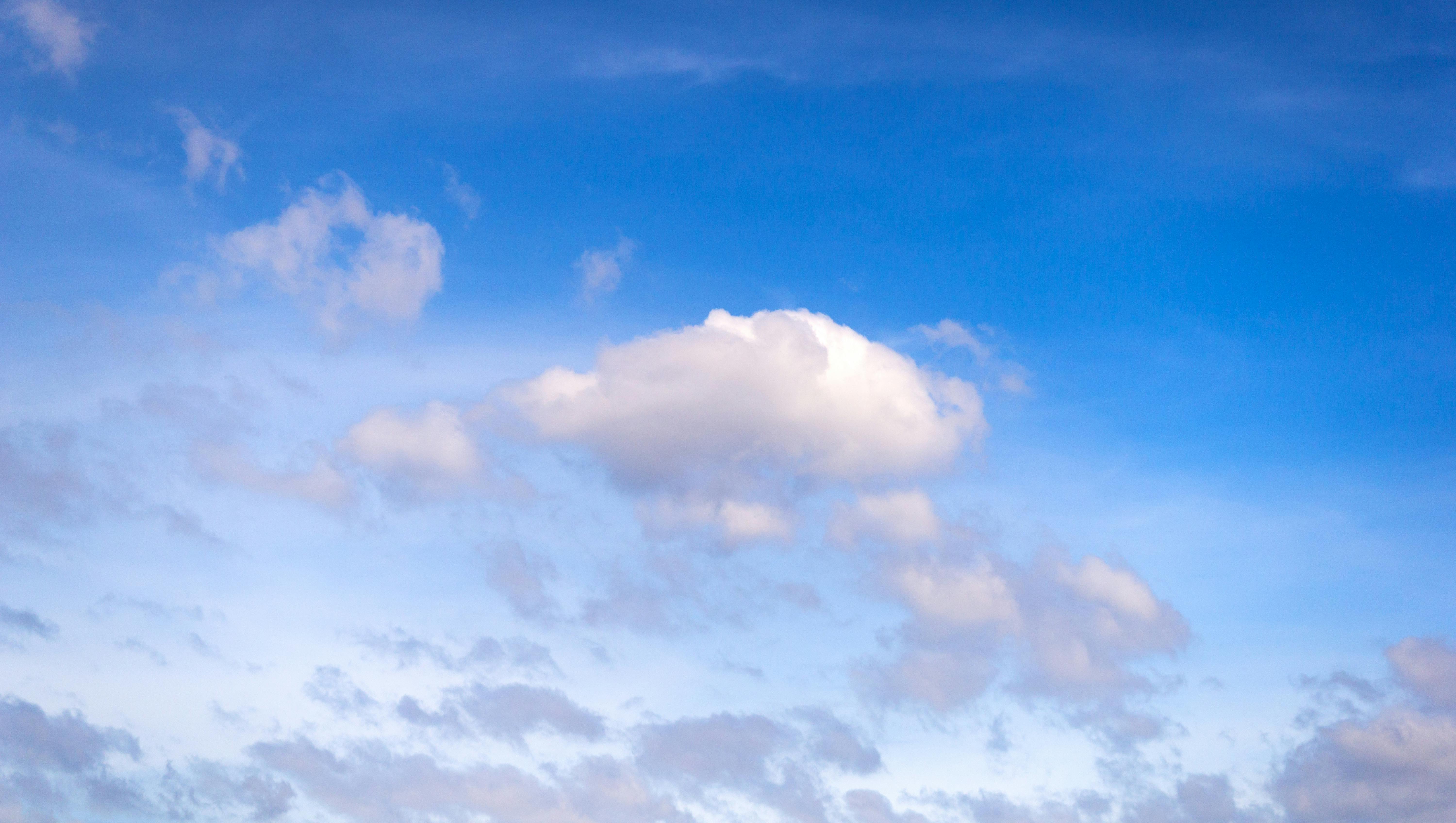 Kostnadsfria Fridfull bild av en klarblå himmel med fluffiga vita moln som sakta driver. Stock foto