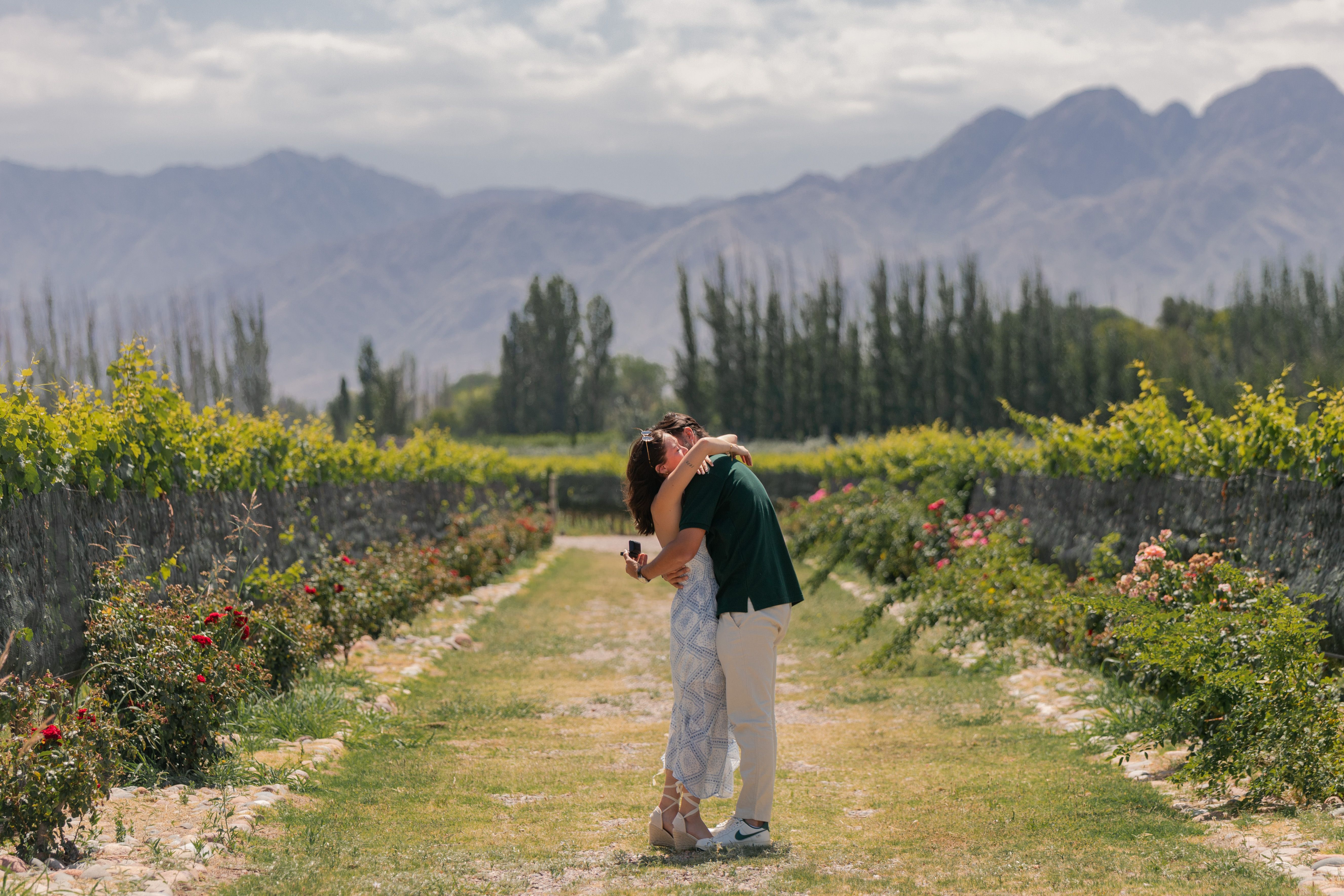 Casal romântico em vinhedo de luxo em Mendoza, Argentina, com montanhas ao fundo.