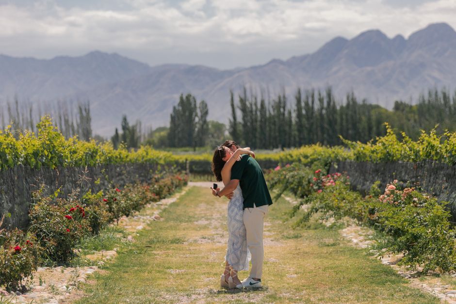 Casal romântico em vinhedo de luxo em Mendoza, Argentina, com montanhas ao fundo.