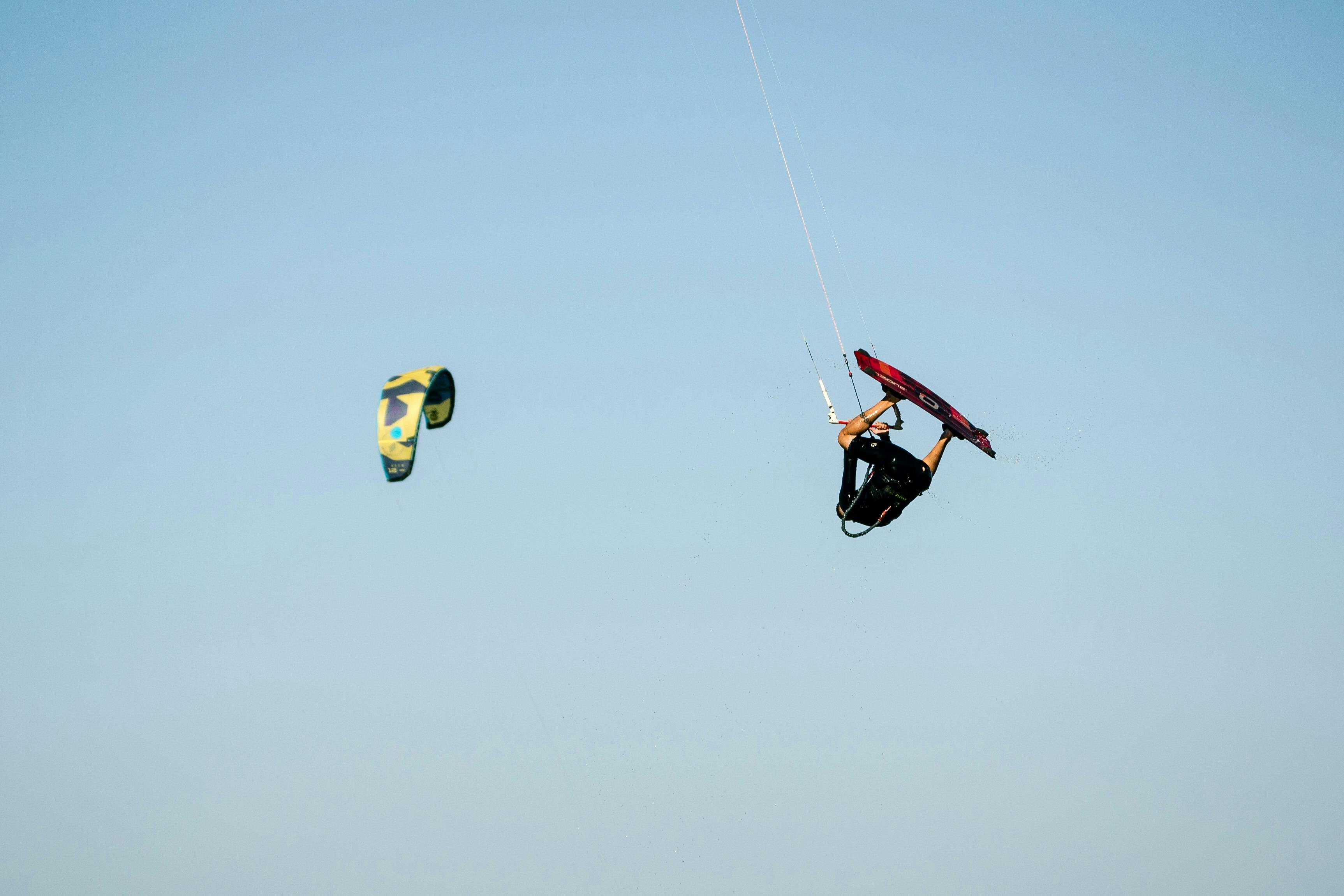 Bezpłatne Doświadczony kitesurfer wykonujący niesamowity manewr powietrzny na tle czystego, błękitnego nieba w Argentynie. Zdjęcie z galerii