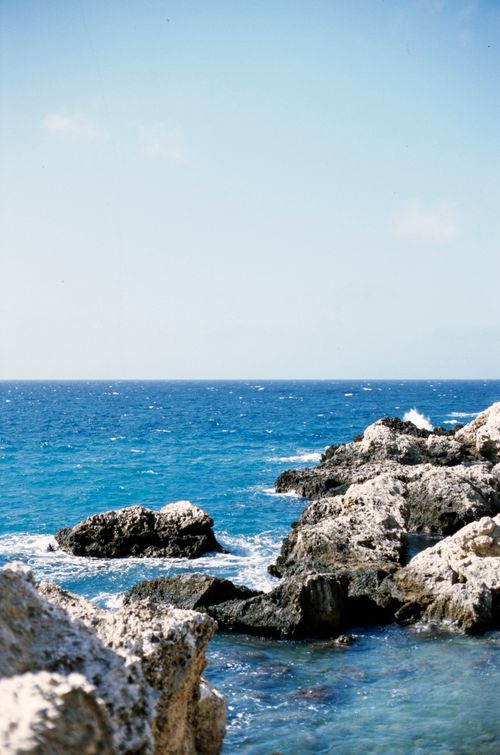 Free A picturesque view of the rocky coastline in Malta with clear blue Mediterranean waters. Stock Photo