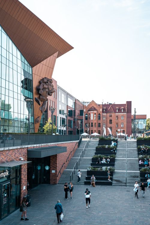 Free Vibrant city scene featuring modern architecture and people in an urban setting. Perfect for travel and lifestyle visuals. Stock Photo
