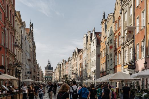 Bustling street in Gdansk's historic center with colorful facades and lively atmosphere.