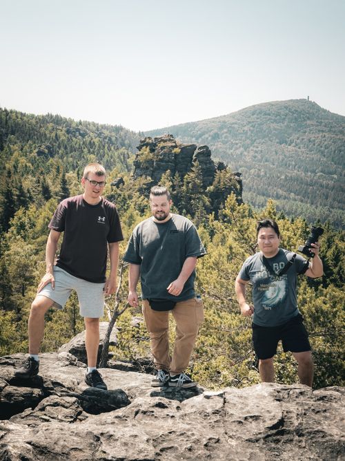 Free Three friends enjoy a scenic hike in Oybin, SN, Germany, surrounded by stunning mountain views. Stock Photo