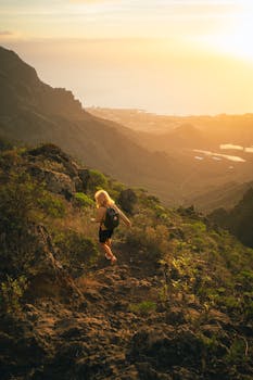 A hiker explores the rugged trails of Ifonche, Spain, during a vibrant sunset.