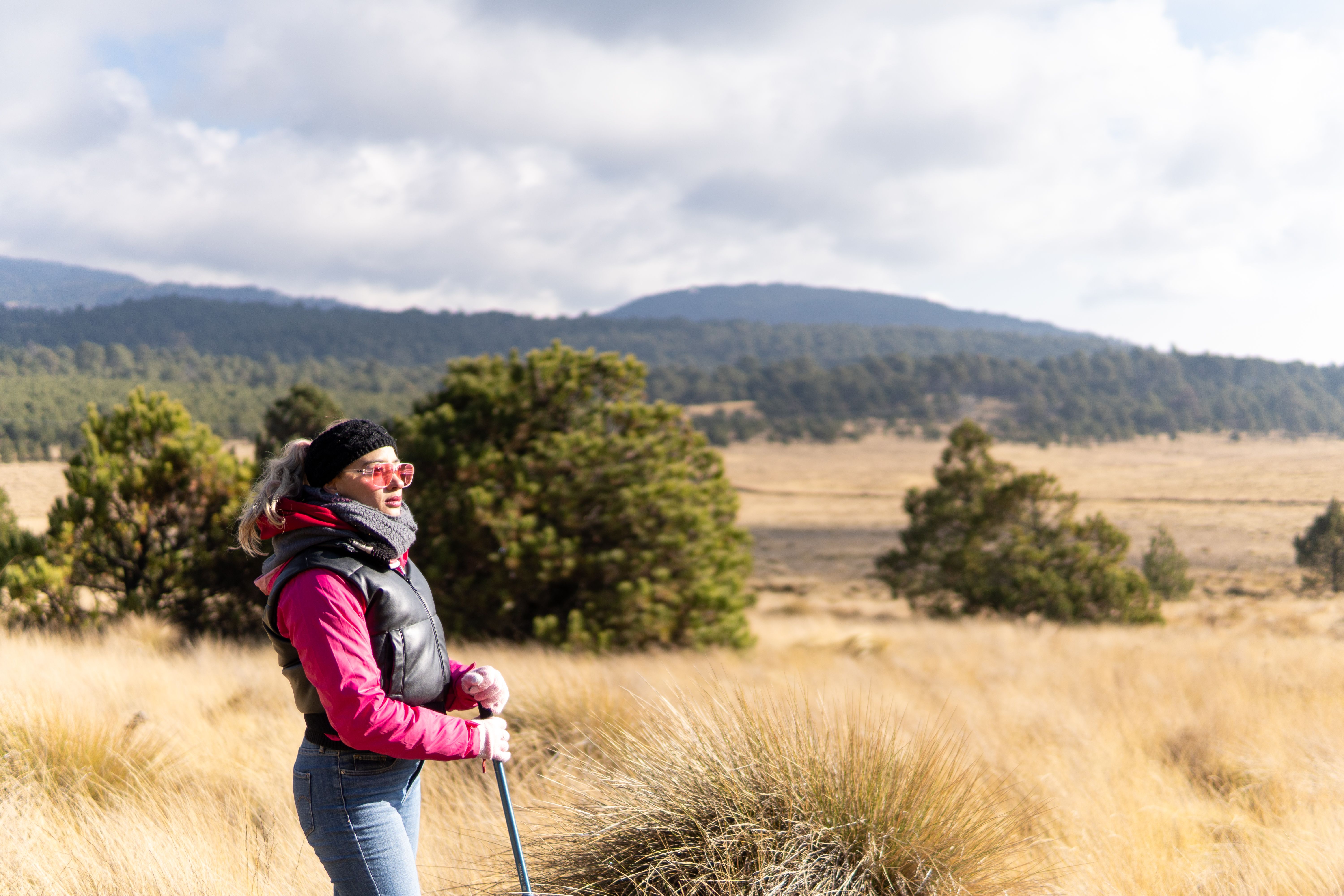 A woman enjoys a hike in the picturesque landscapes of Puebla, Mexico, on a sunny day.