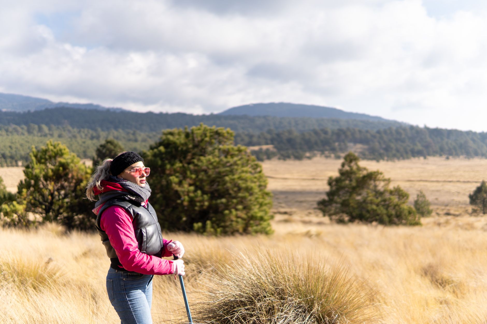 A woman enjoys a hike in the picturesque landscapes of Puebla, Mexico, on a sunny day.