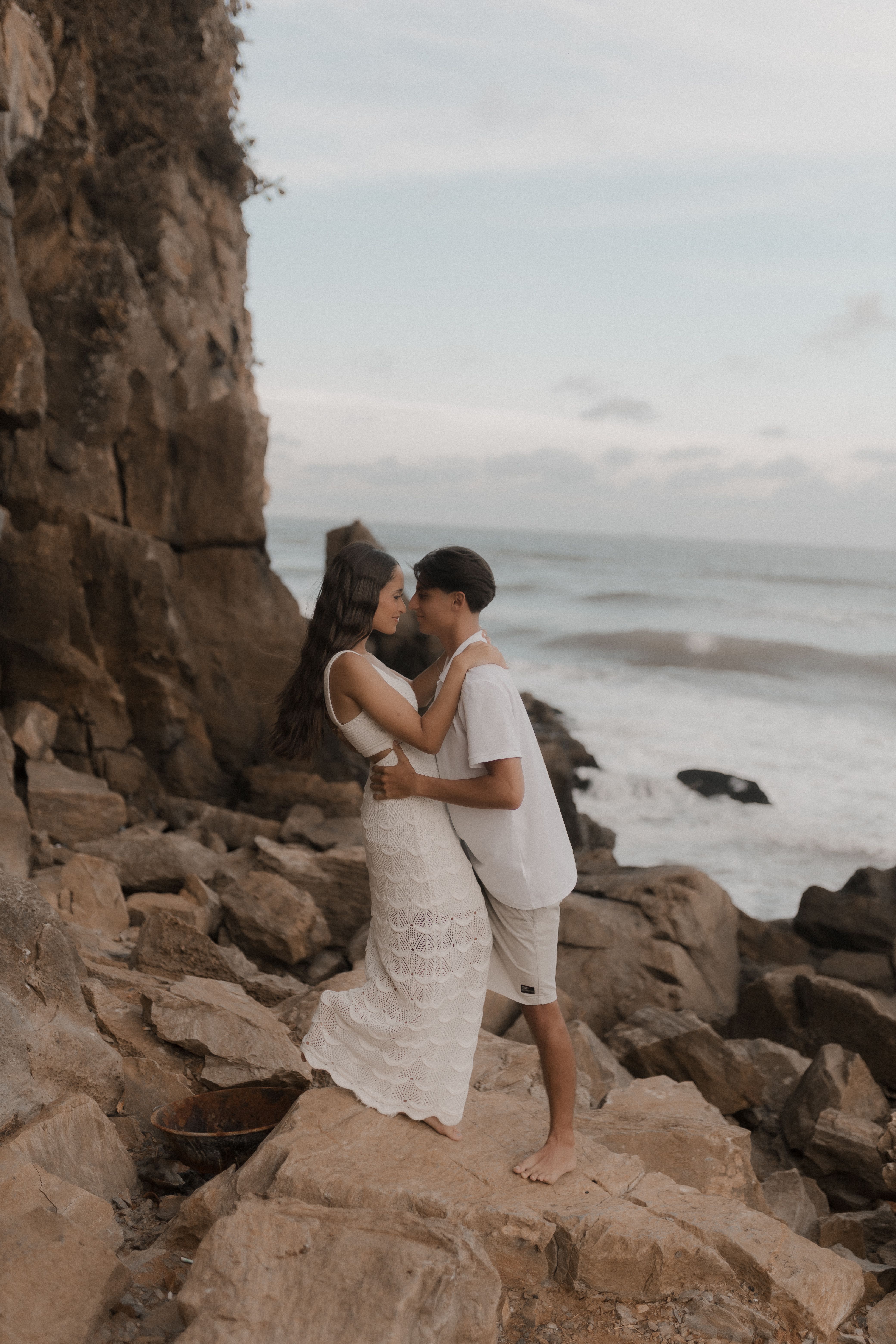 Romantic Couple Embracing on Rocky Beach · Free Stock Photo