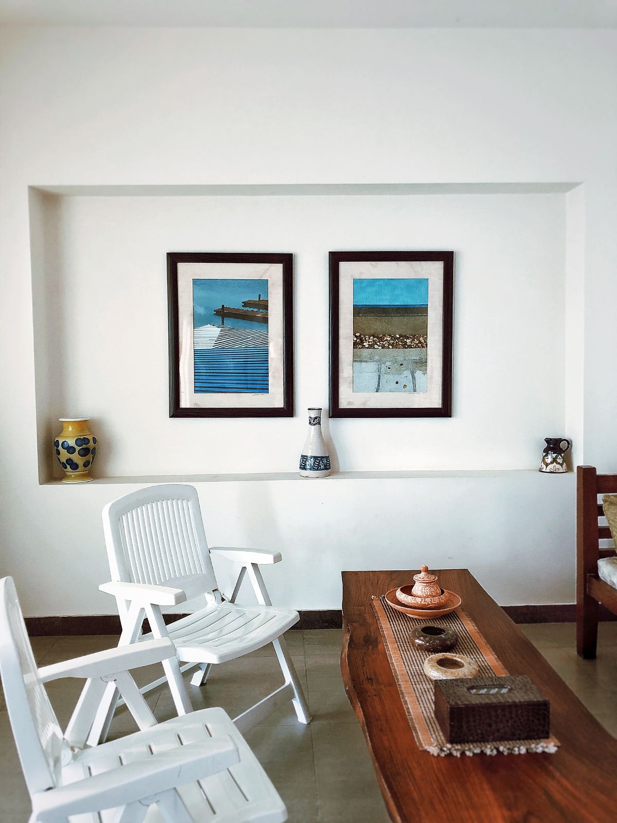 Artistic coastal dining area with a natural wood table and white chairs
