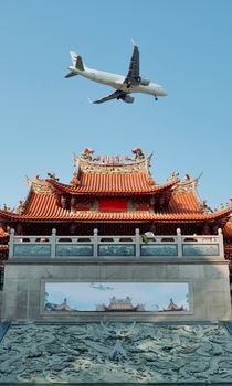A jet plane passes over a traditional Chinese temple under a clear blue sky.