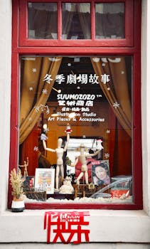 Charming art studio window with mannequins and creative accessories on display.