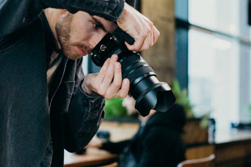 Hombre Sujetando Una Cámara Dslr Negra