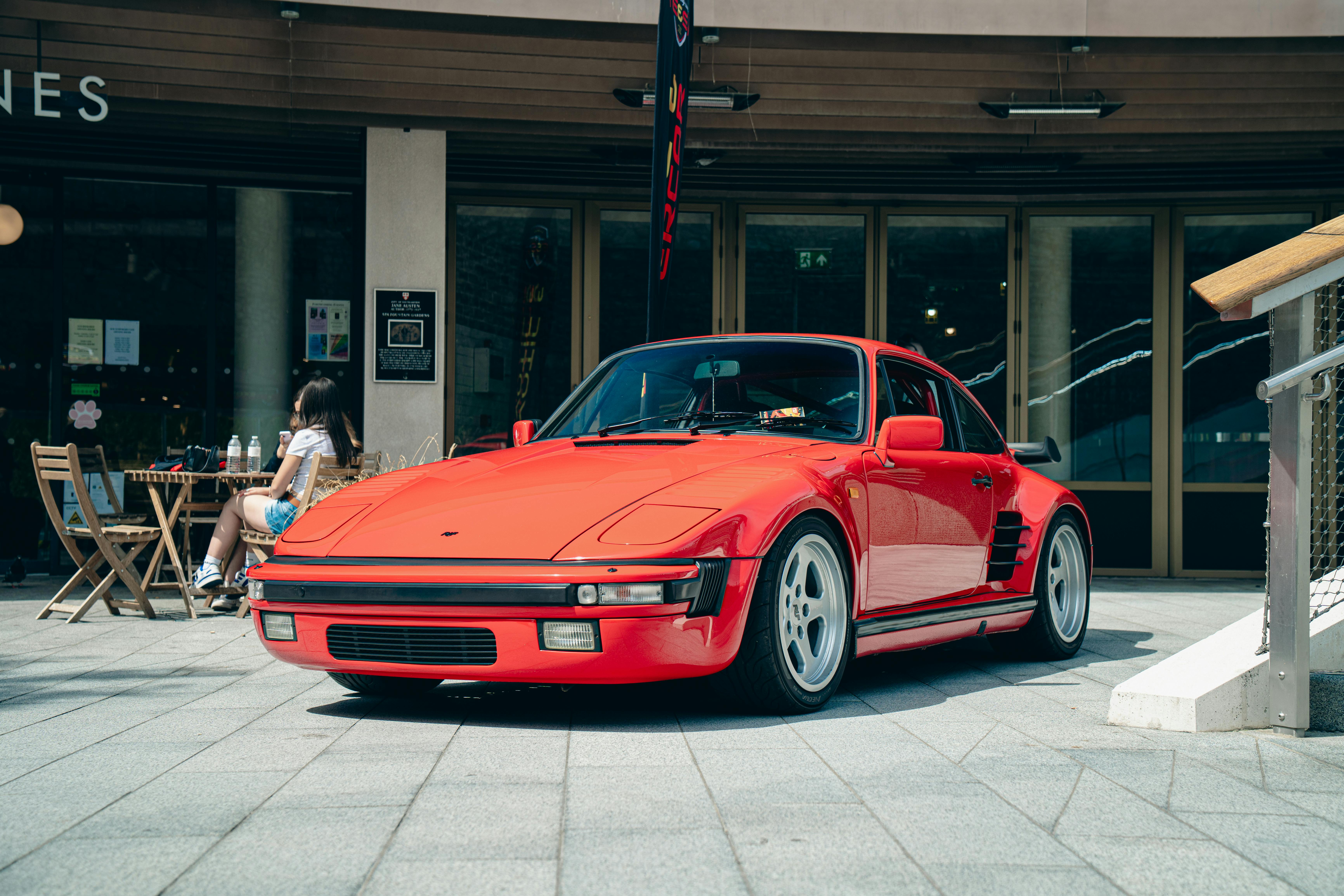 Free Classic red sports car parked outdoors in Southampton, England with a cafe in the background. Stock Photo