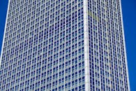 高耸的玻璃摩天大楼，其现代化的立面映衬着清澈的蓝天