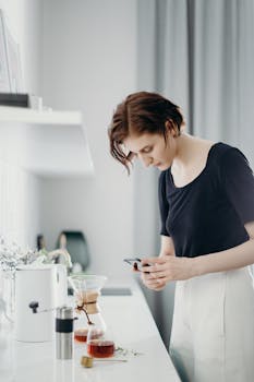 一名女子在现代化厨房里拍摄了一张咖啡设备的照片