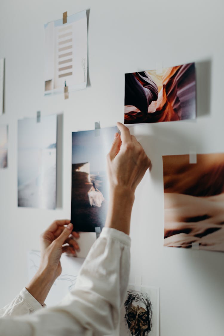 Photo Of Person Putting Photo On Wall