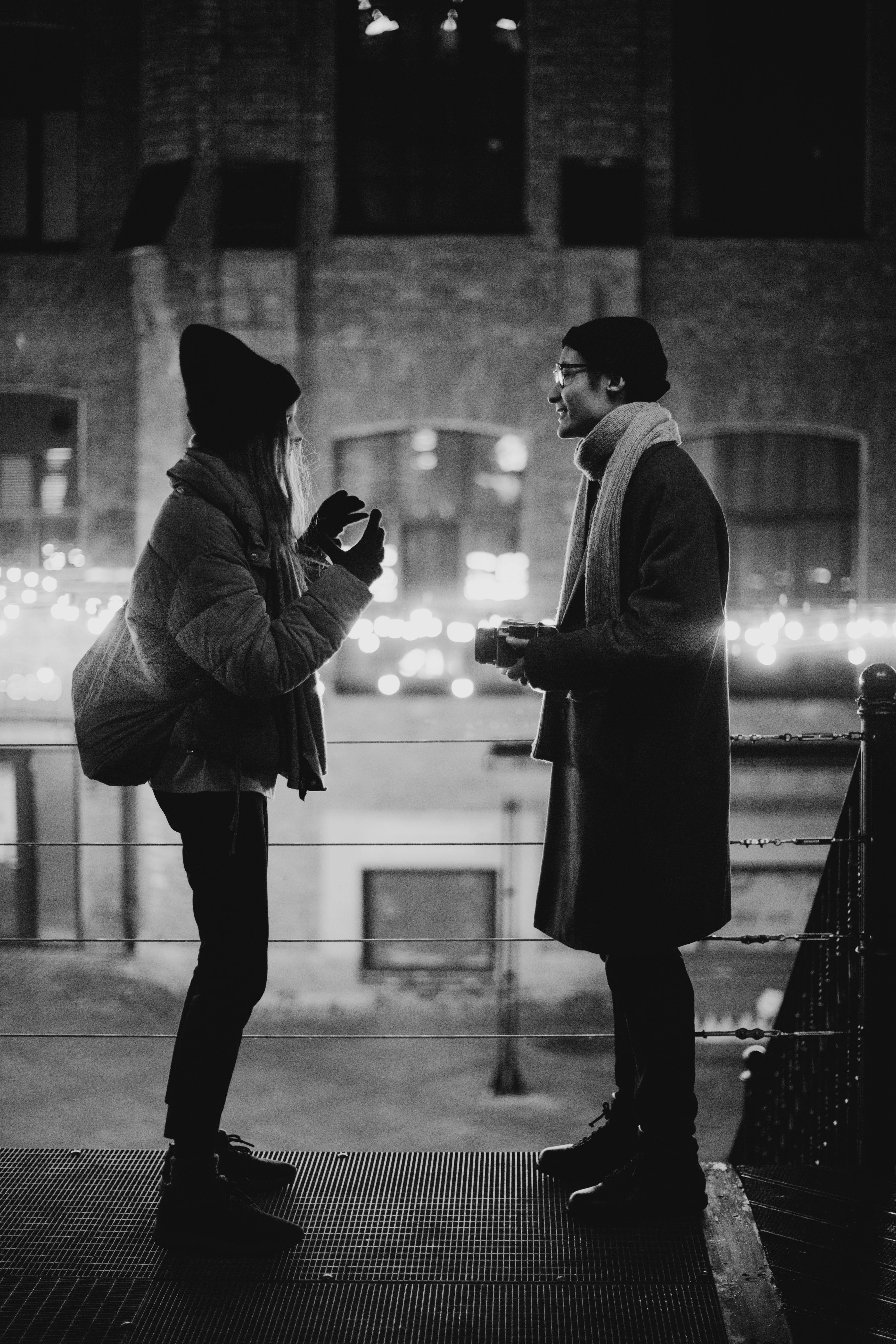 grayscale photography of talking man and woman