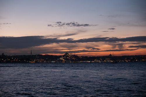 Free Capture of Istanbul skyline at dusk, featuring iconic architecture and warm sunset hues reflecting over the water. Stock Photo