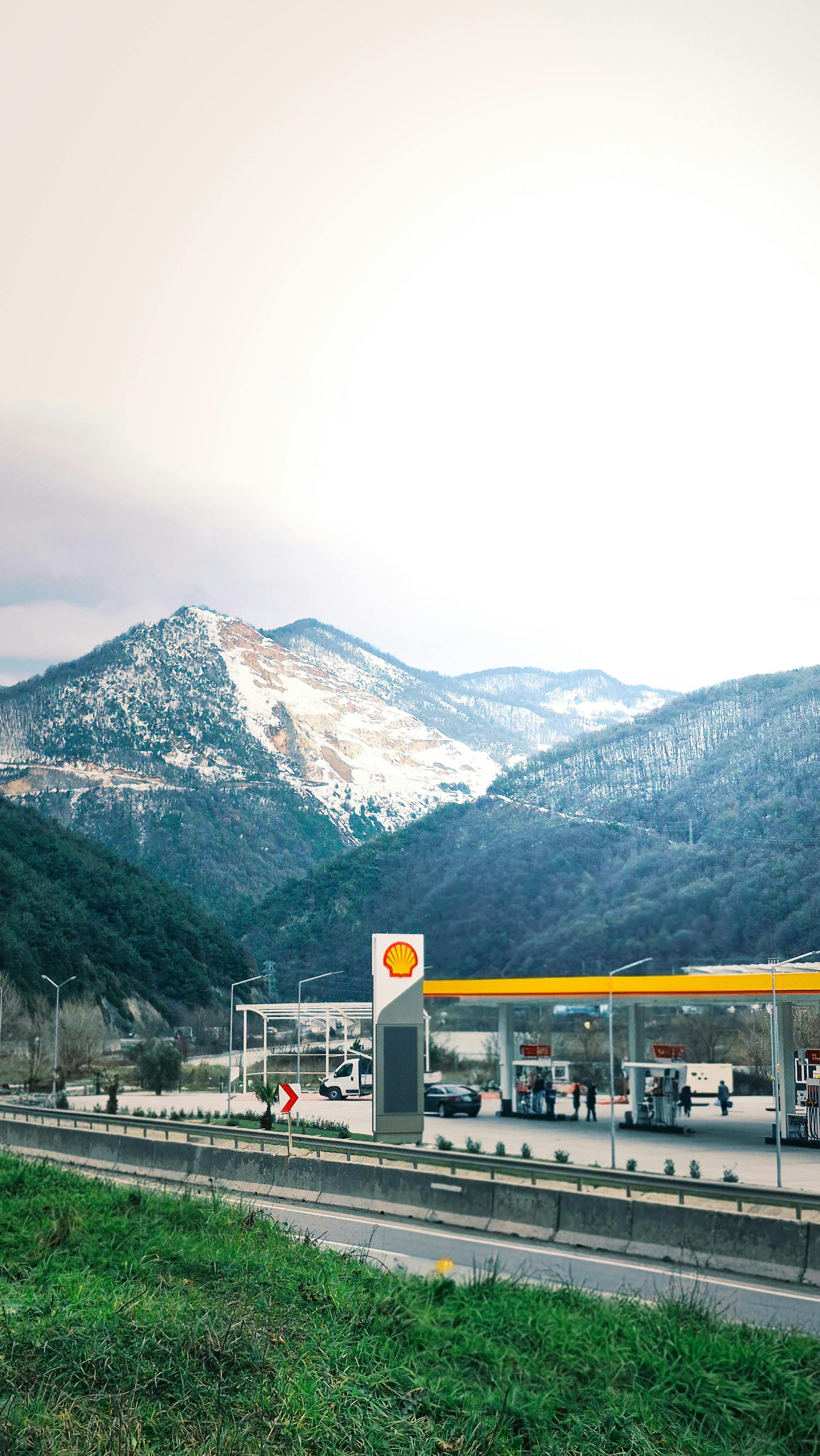 Scenic view of a gas station with mountainous backdrop in winter season.