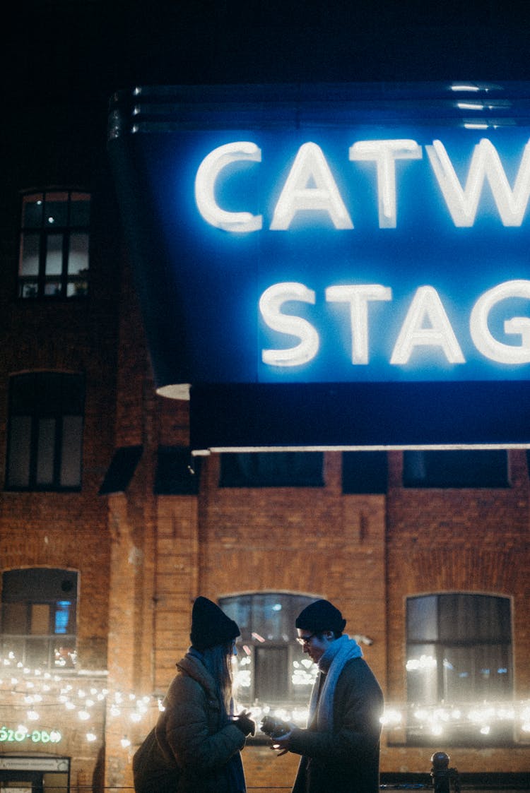  Man And Woman Talking Infront Of Signage