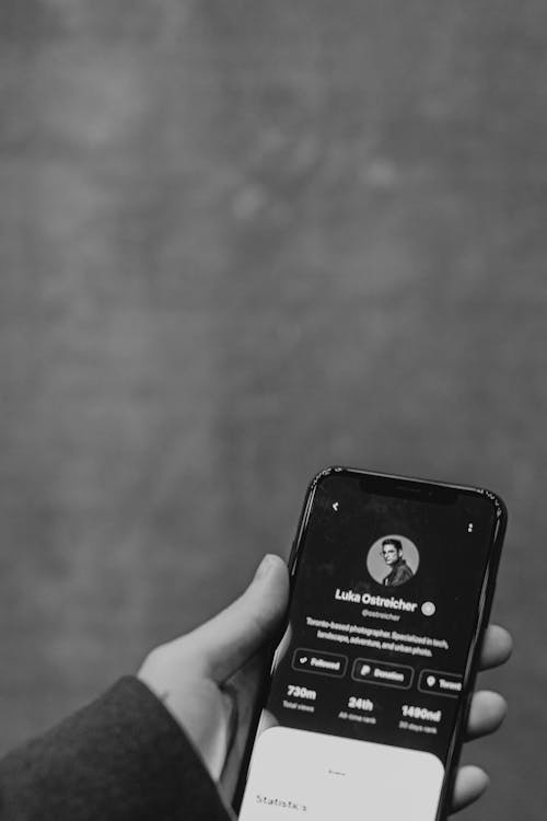 Greyscale Photo of Person Holding Smartphone