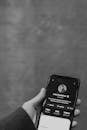 Greyscale Photo of Person Holding Smartphone