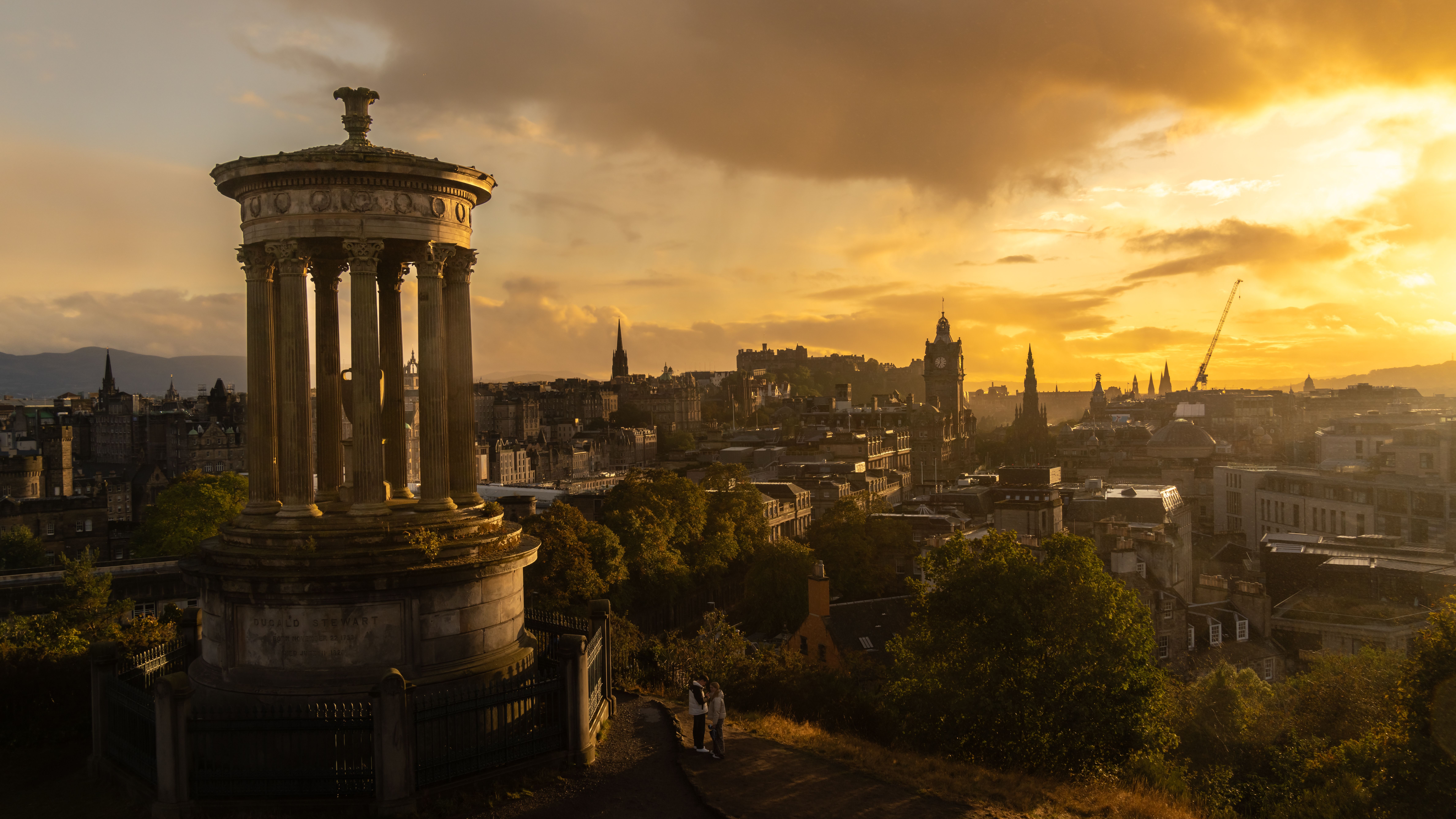 De franc Espectacular posta de sol de l'horitzó d'Edimburg des de Calton Hill amb el monument a Dugald Stewart en primer pla. Foto d'estoc