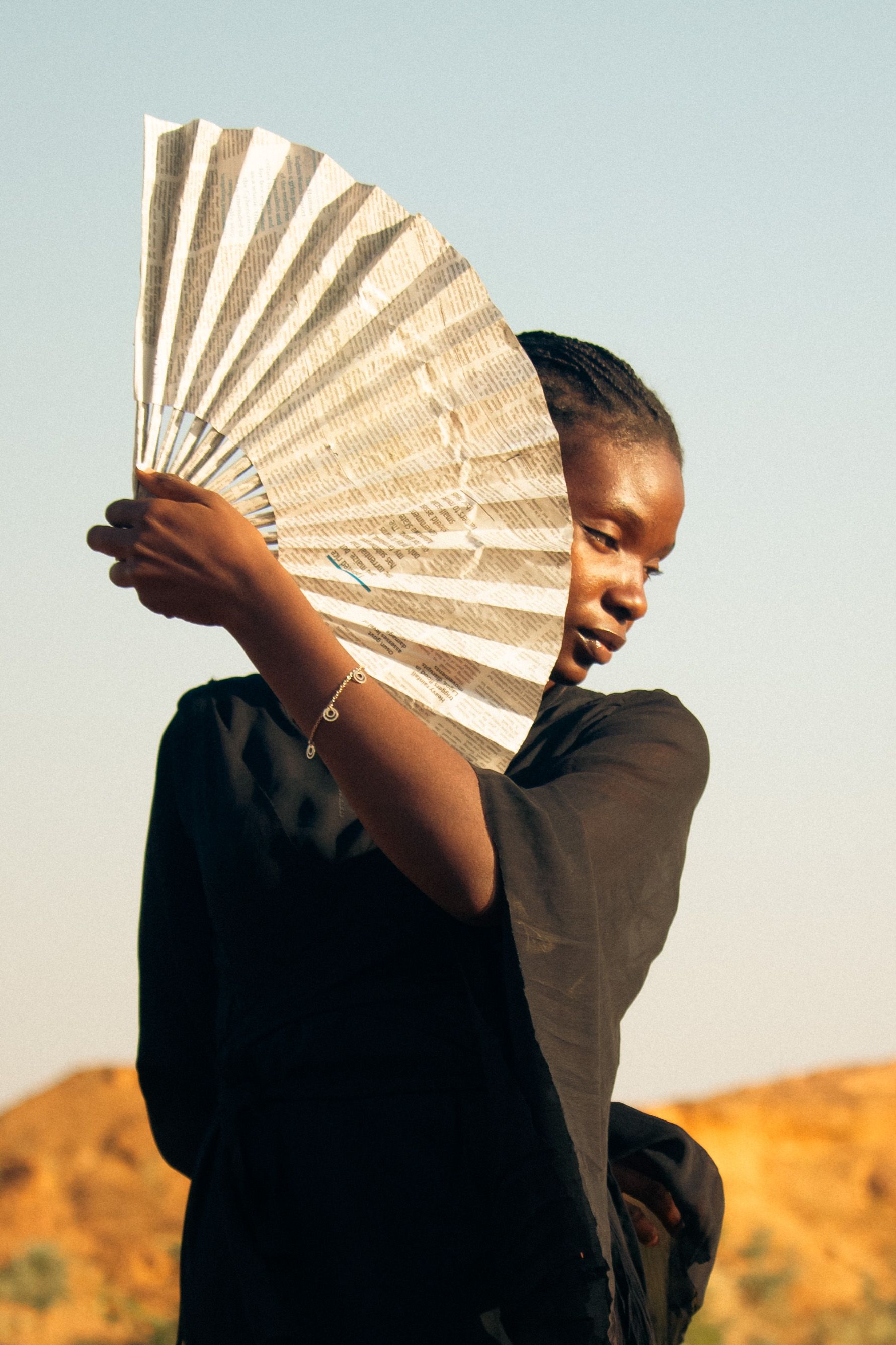 Woman with Fan in Sunny Outdoor Setting · Free Stock Photo