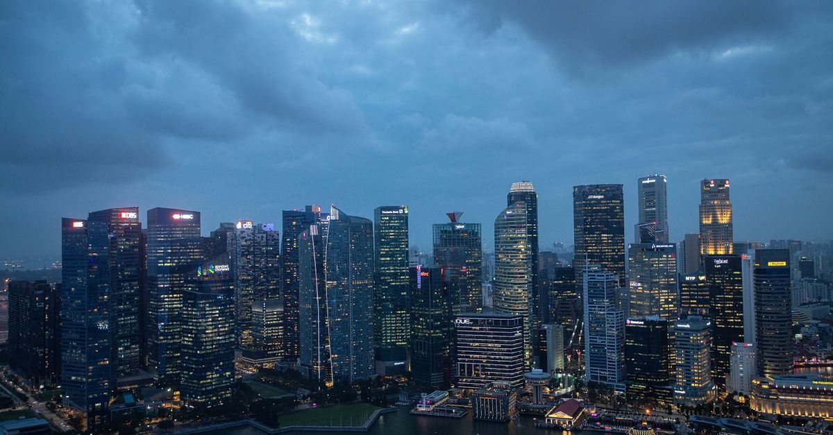 The Singapore skyline lit up at dusk, seen from across the water