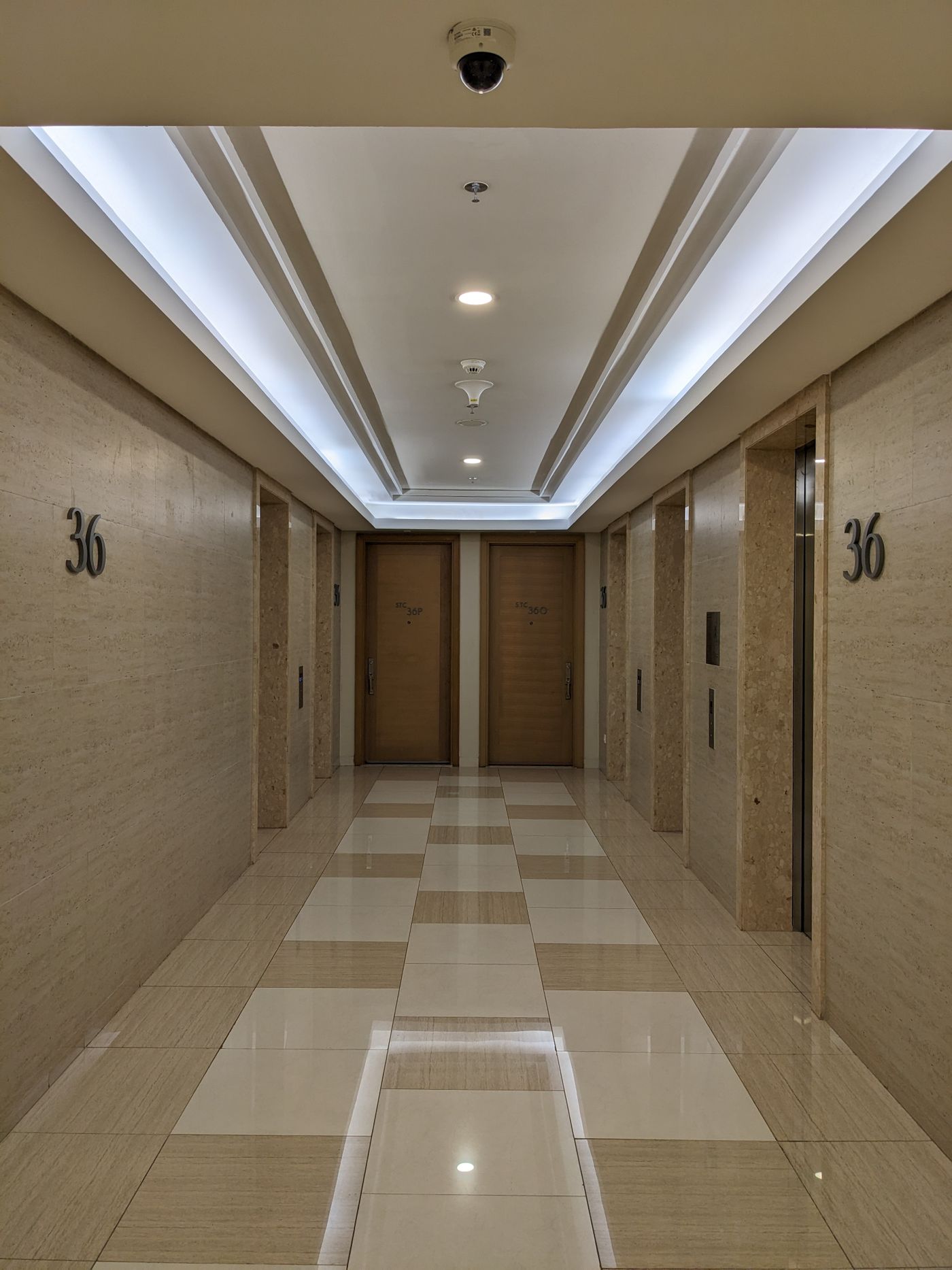 Well-lit hotel corridor with consistent door finishes