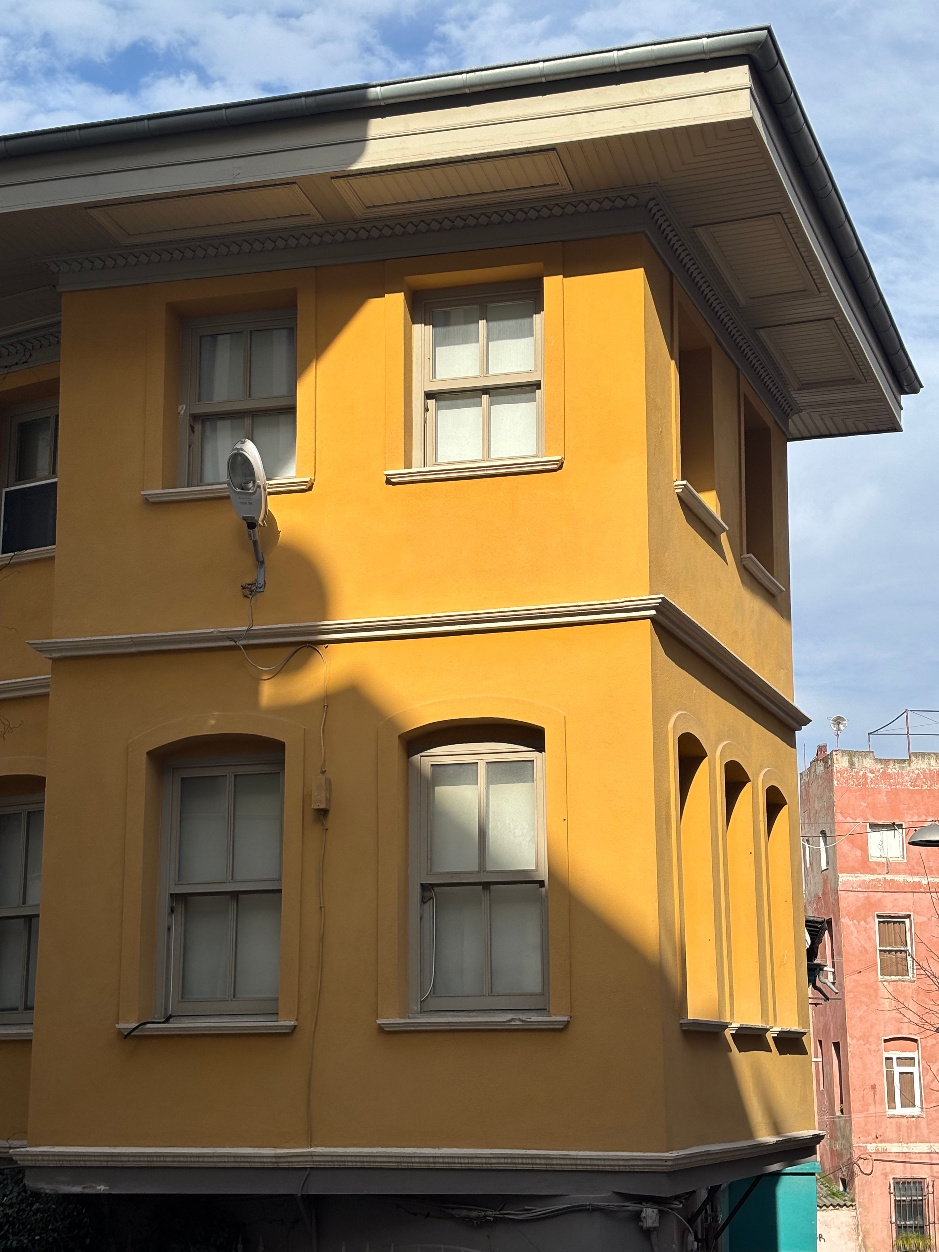 Vibrant Yellow Building in Urban Setting · Free Stock Photo