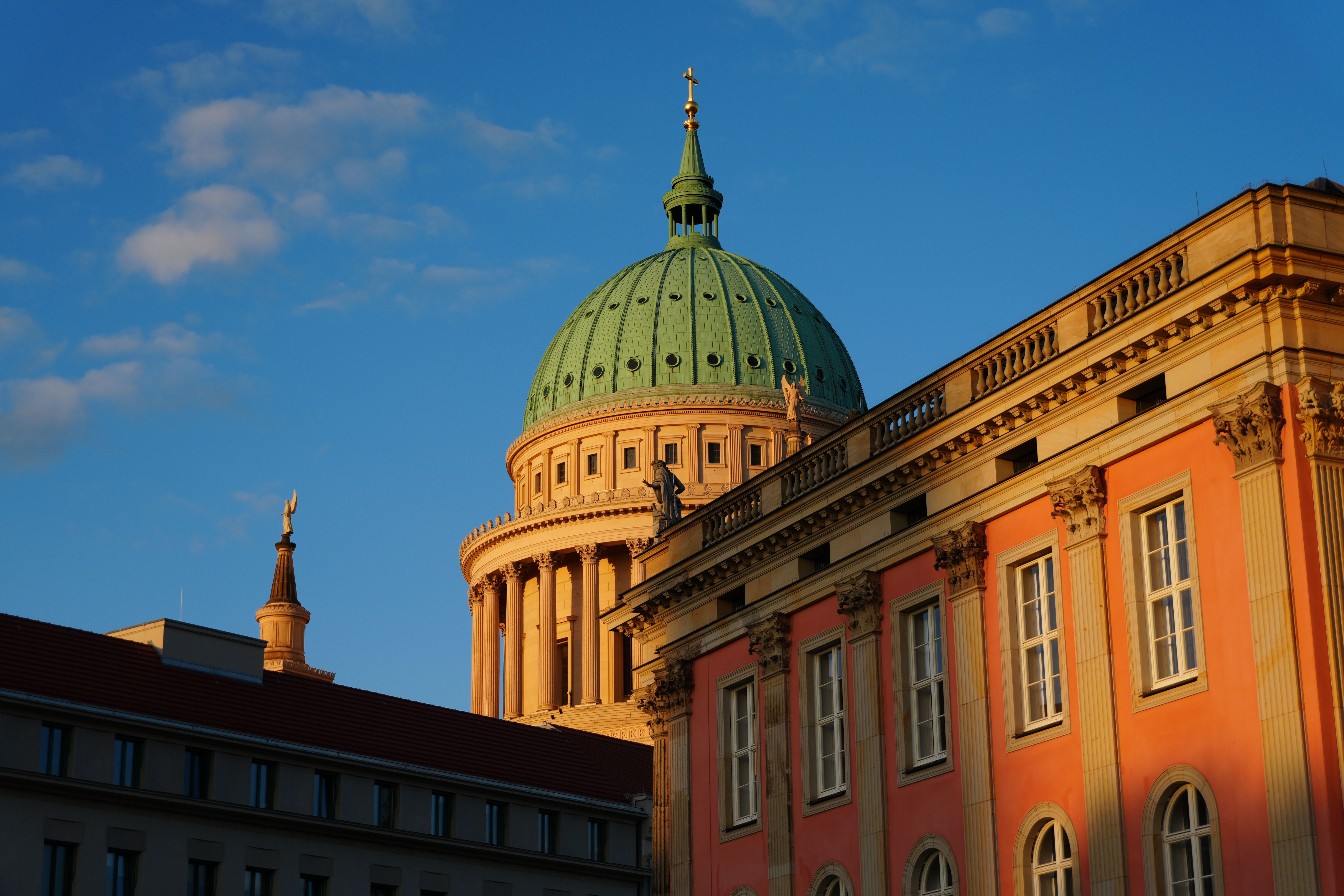 Green dome of St. Nicholas Church above historic Potsdam, Germany, with no people visible in warm evening light