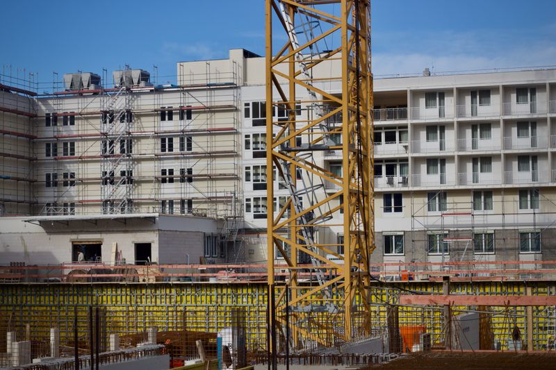Urban commercial construction site with crane and building
