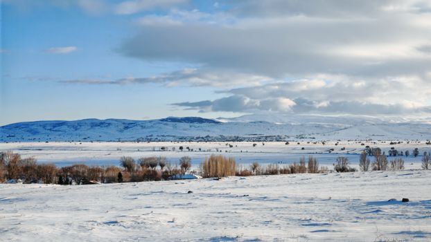 Scenic winter view of snowy fields and mountains in Orta, Çankırı, Türkiye.