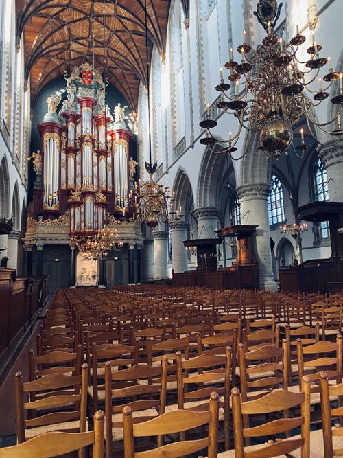 Free A stunning pipe organ inside a historic Dutch cathedral with ornate chandeliers and wooden seating. Stock Photo
