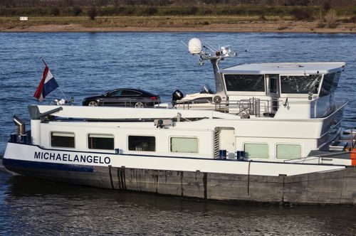 Free A sleek cargo ship named Michaelangelo sails on the Rhine, showcasing modern transport. Stock Photo