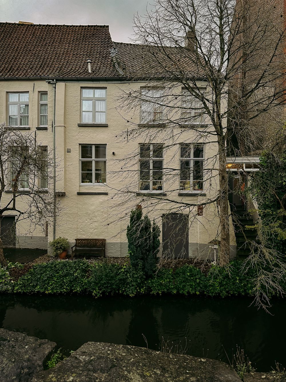 Case de pe canal în Bruges, iarna, cu zăpadă pe acoperișuri