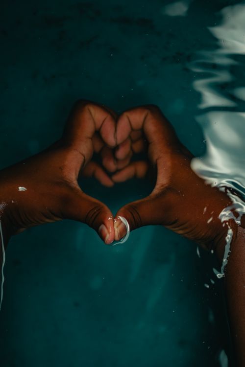 Free Two hands form a heart shape underwater, symbolizing love and unity. Stock Photo