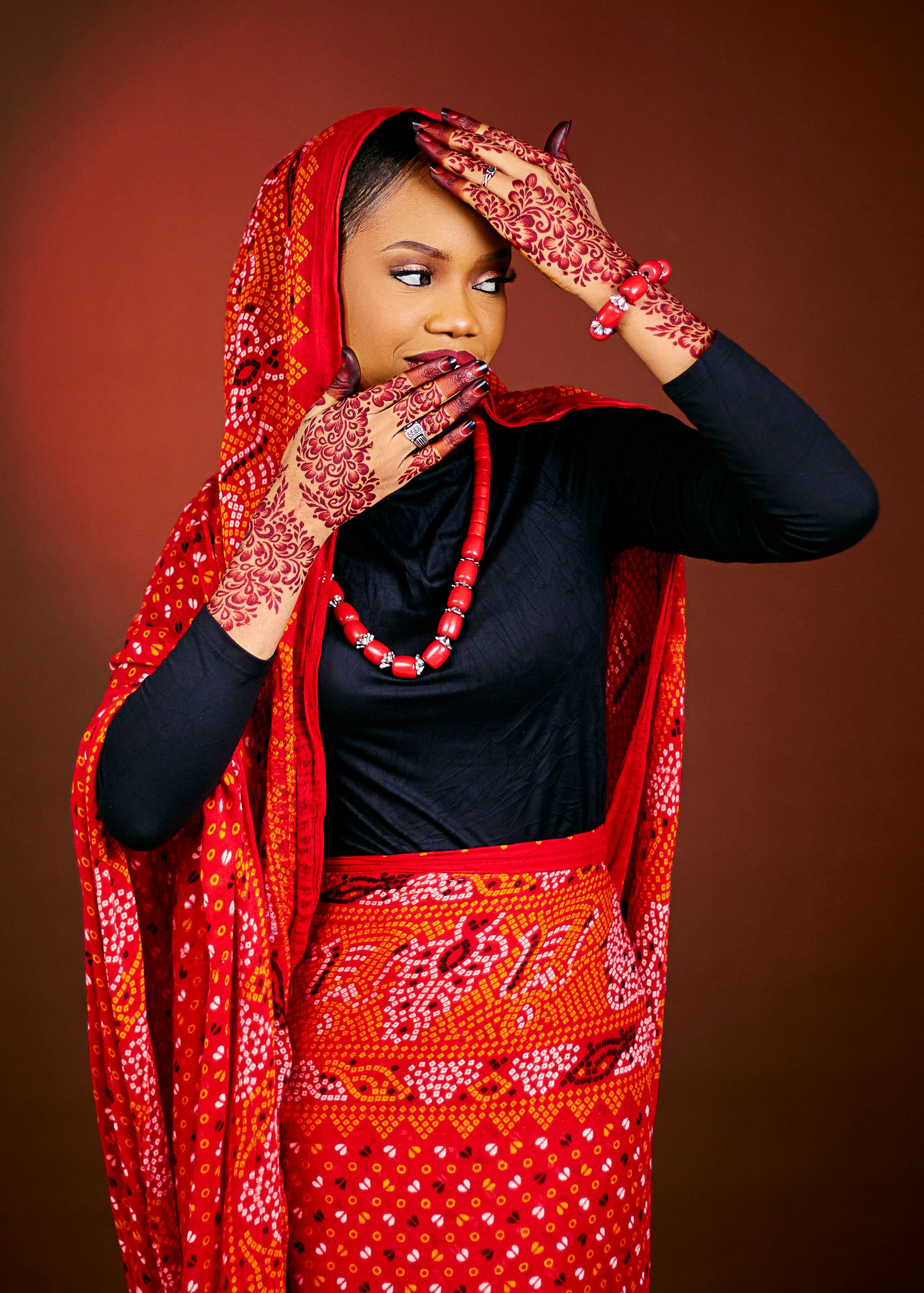 Woman in traditional vibrant attire with intricate henna designs, illustrating cultural beauty.