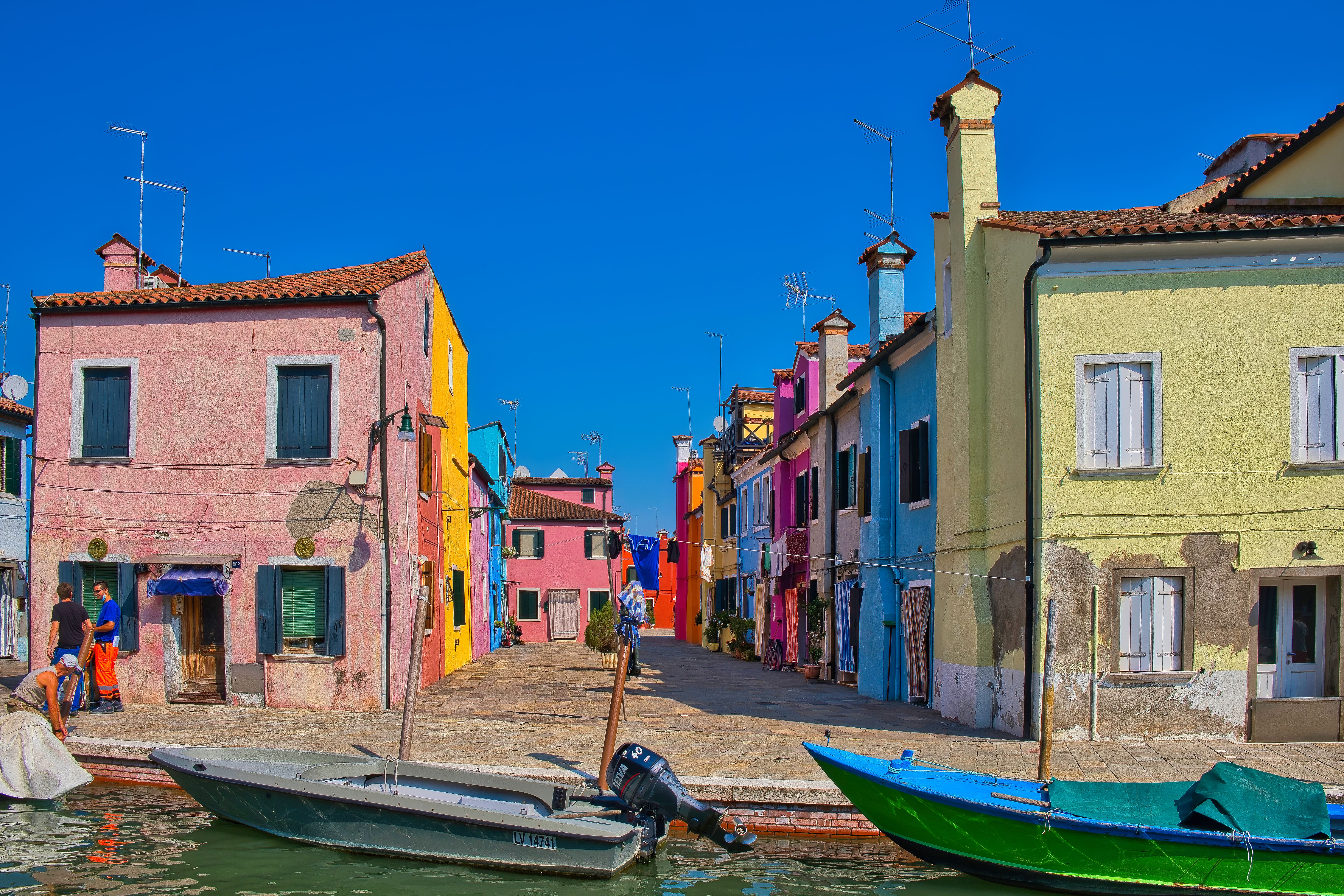 Scenic view of the vibrant and colorful houses along the canal in Burano, Venice, Italy. Scenic view of the vibrant and colorful houses along the canal in Burano, Venice, Italy.