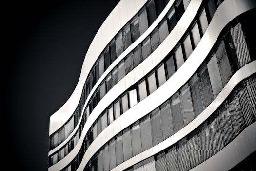 这张黑白照片中的现代高层建筑，拥有优雅的波浪形立面和玻璃窗