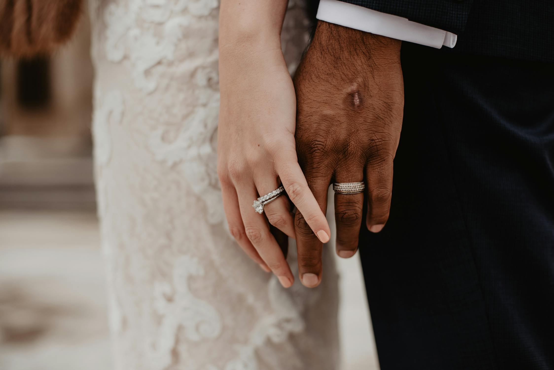 two people wearing silver colored wedding rings