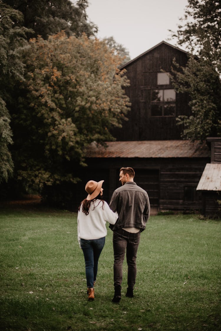 Man And Woman Standing On Green Grass