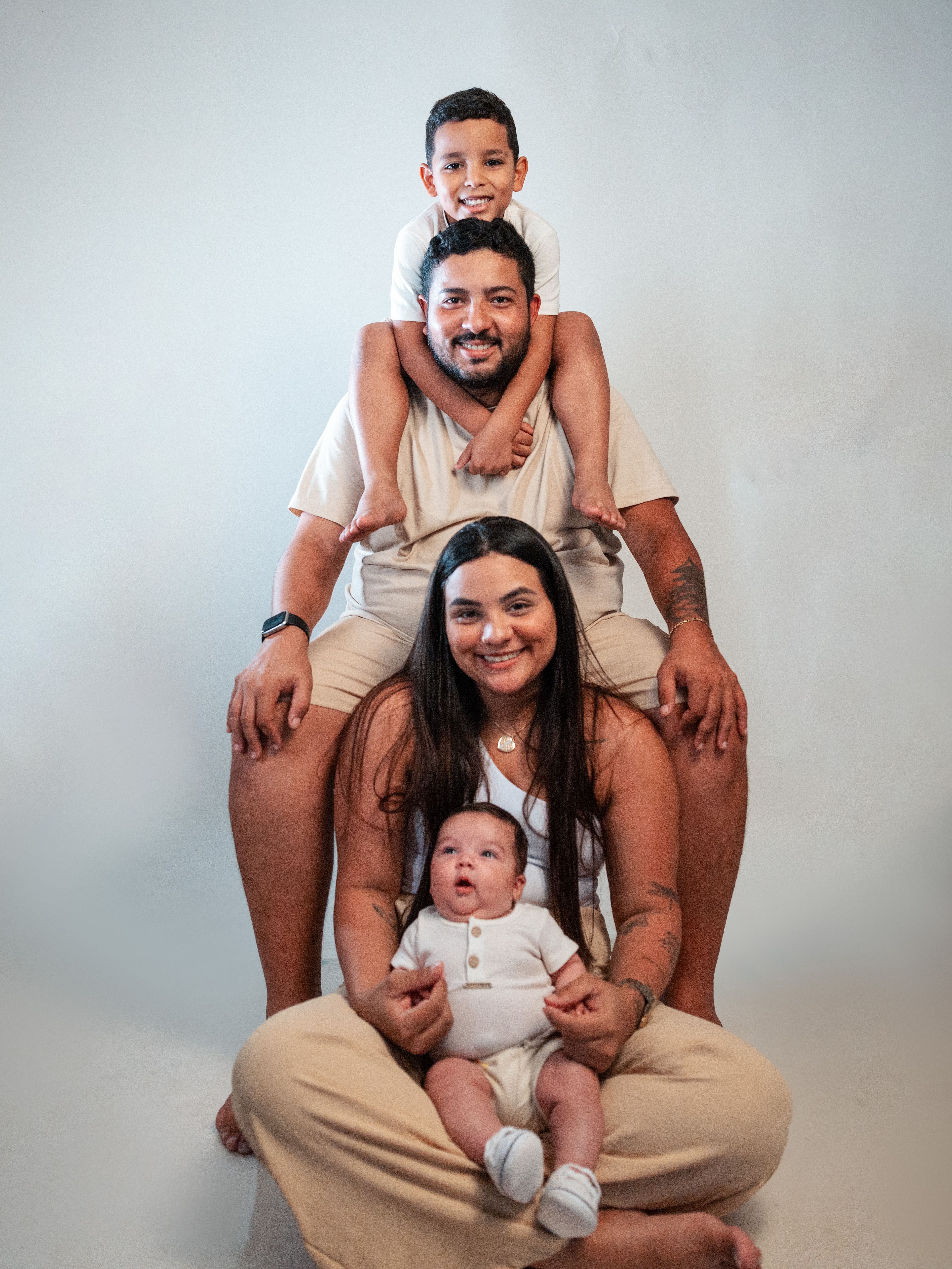 A joyful family portrait featuring parents with their children, captured in a cozy indoor setting.