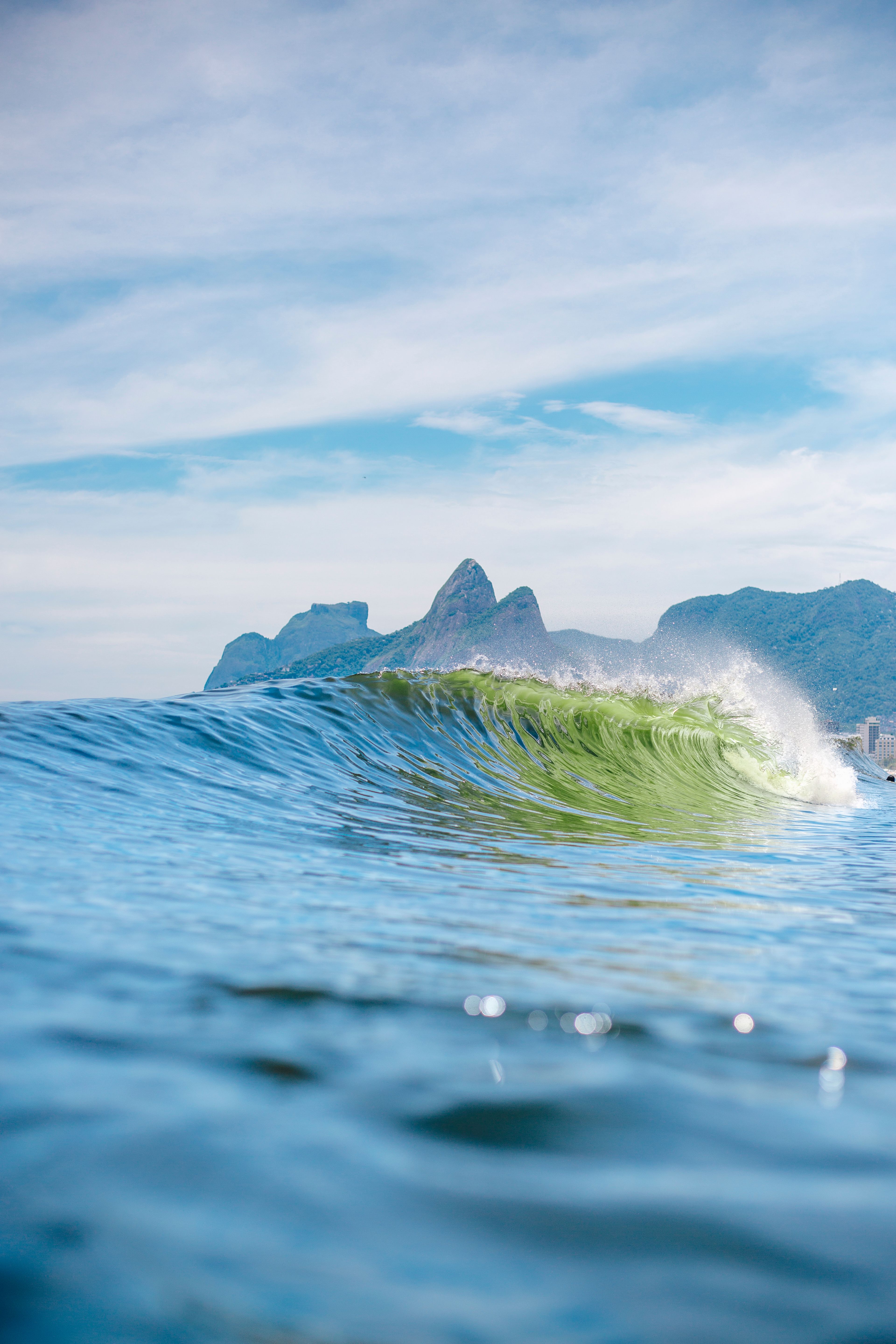 Majestic wave crest with Dois Irmãos in the background at Ipanema Beach, Rio de Janeiro.