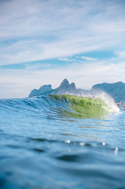 Majestic wave crest with Dois Irmãos in the background at Ipanema Beach, Rio de Janeiro.