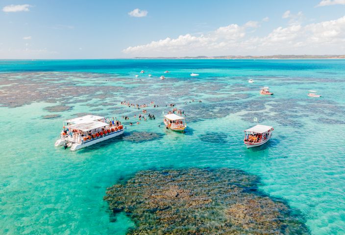 Discover the stunning turquoise tide pools of Maragogi, Brazil, under a clear blue sky.