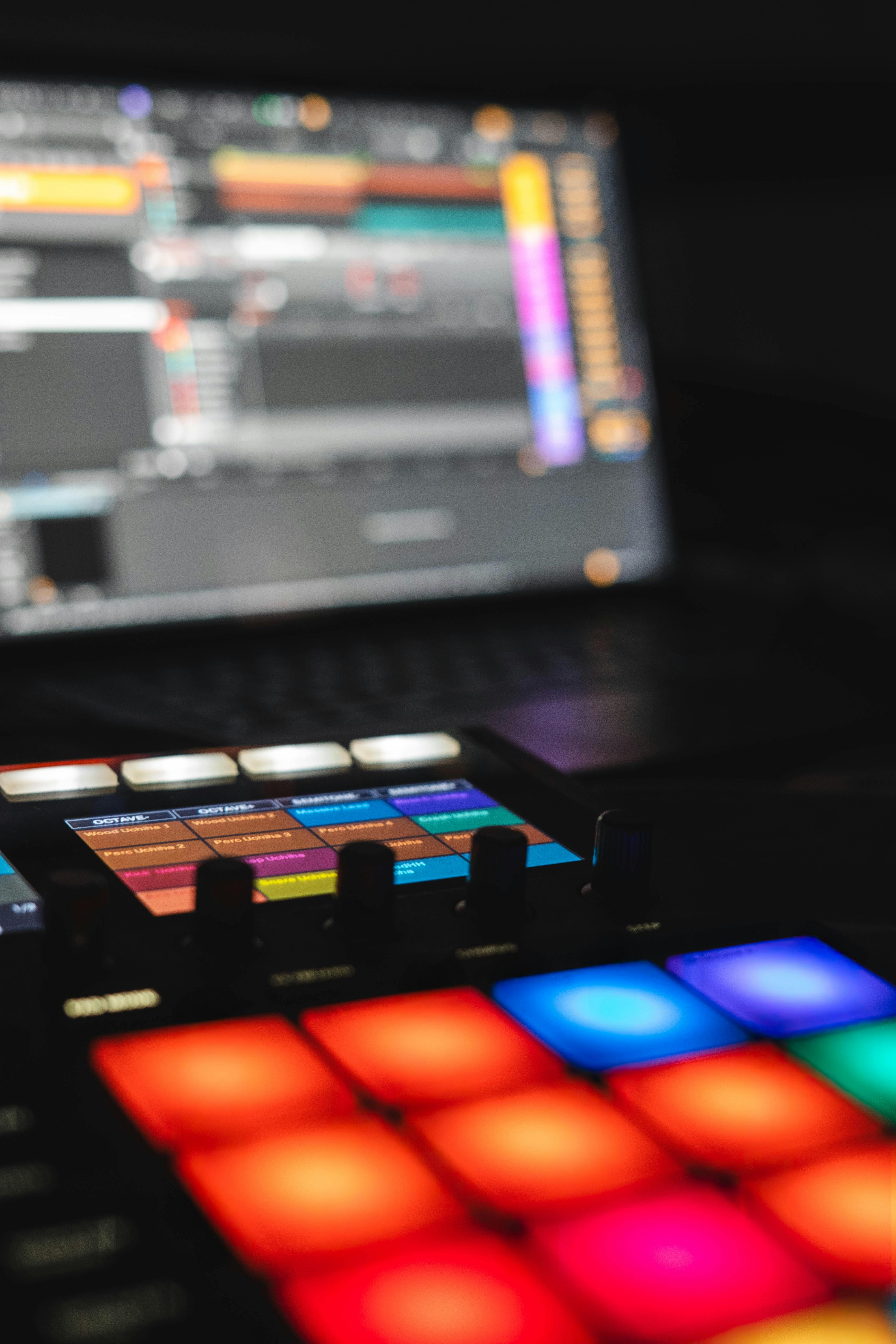 Vibrant music production setup featuring a digital audio workstation and illuminated pads.