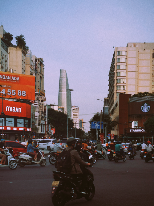 Free Busy intersection in Ho Chi Minh City with Bitexco Tower in the background, showcasing urban life in Vietnam. Stock Photo