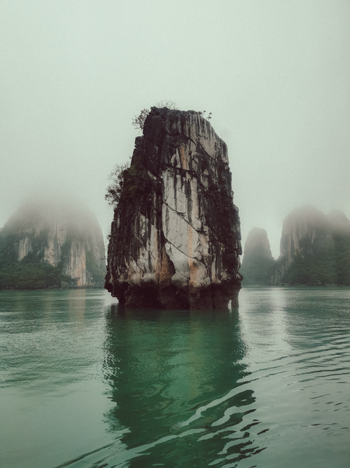 Free Limestone karst in foggy Halong Bay, Vietnam, showcasing natural beauty and tranquility. Stock Photo